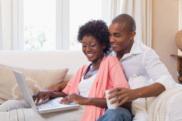 istock Cute couple relaxing on couch with laptop and coffee 843820366