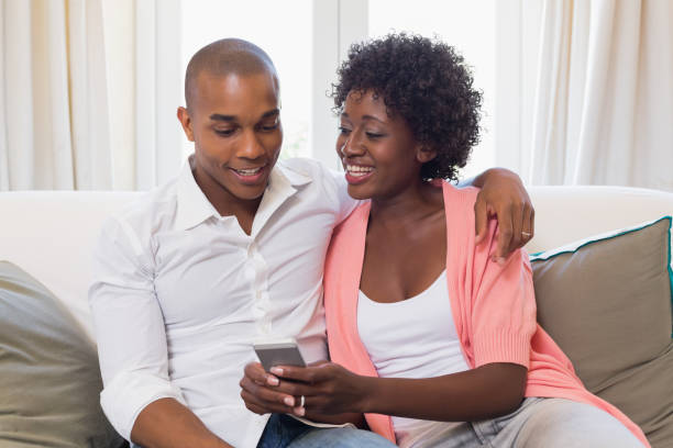 istock Cute couple relaxing on couch with smartphone 843820400