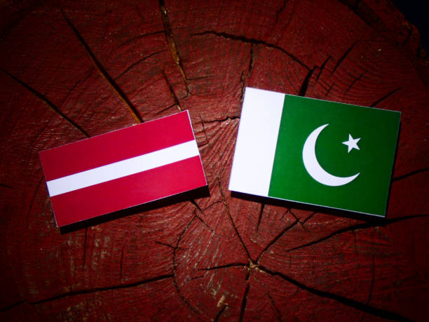 istock Latvia flag with Pakistan flag on a tree stump isolated 843830040