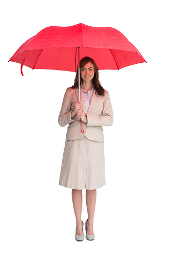 Attractive businesswoman holding red umbrella against white background