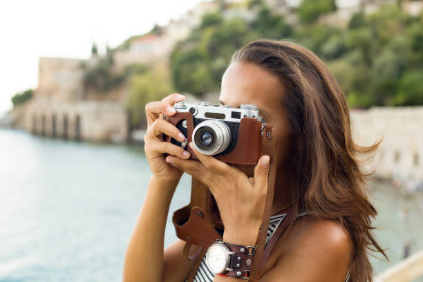 istock Woman photographing with vintage camera 843833452