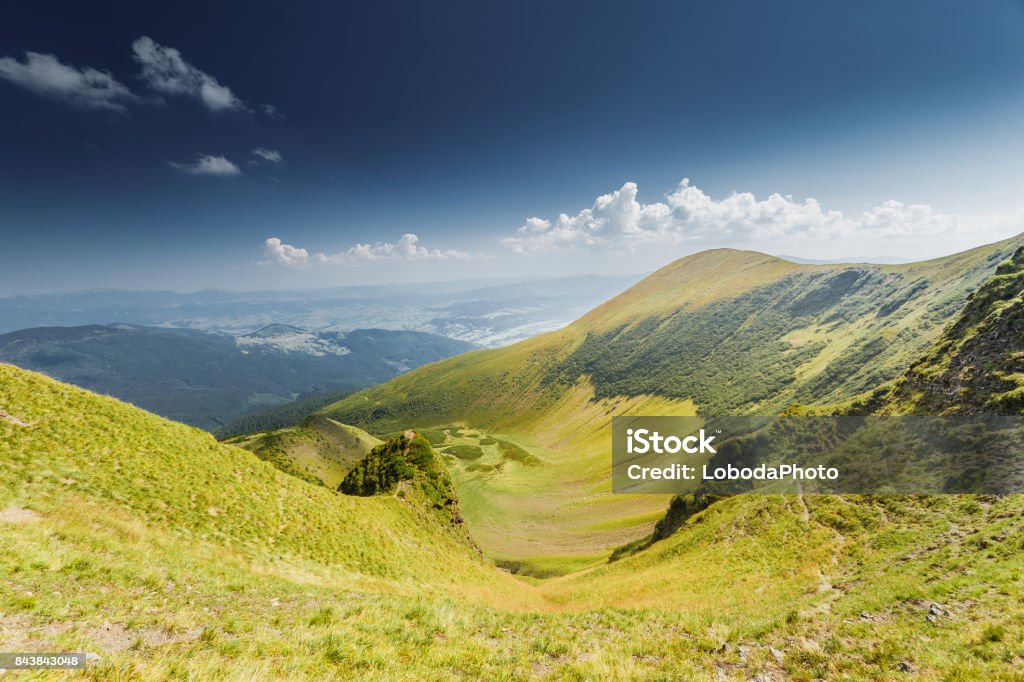 Summer landscape in mountains Summer landscape in mountains and the dark blue sky with clouds Agricultural Field Stock Photo