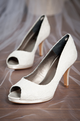 White wedding shoes and veil of the bride on her wedding day