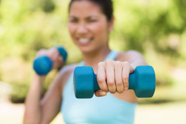 istock Blurred woman exercising with dumbbells in park 843853726