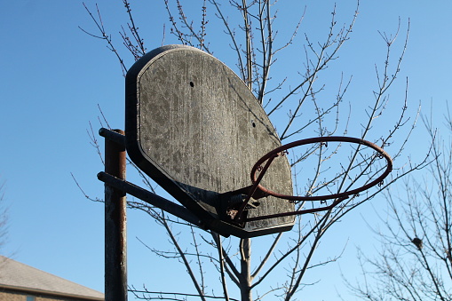 Basketball hoop with morning spring frost and blue sky