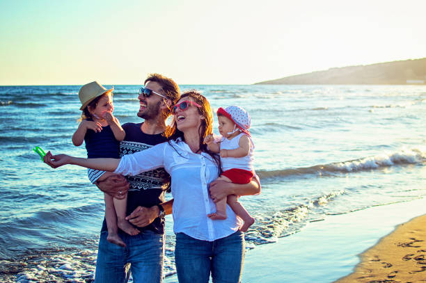 istock Parents with daughters flying kite together at tropical sunny beach 843860968