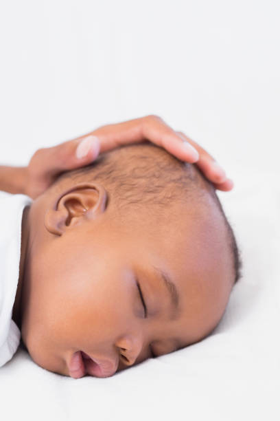 istock Adorable baby boy sleeping with fathers hand on head 843870582