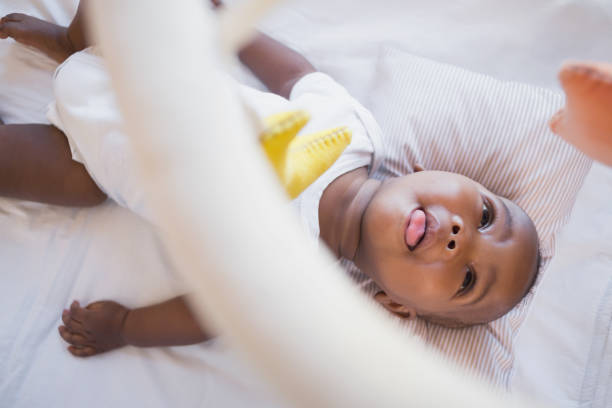 istock Adorable baby boy lying in his crib playing with mobile 843870698