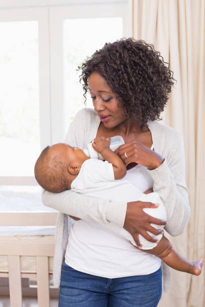 istock Happy mother feeding her baby boy his bottle 843870808