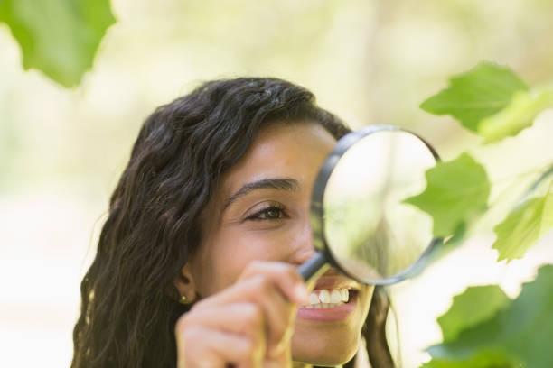 istock Woman examining leaves with magnifying glass 843871032