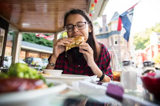 Photo of The pretty 16 years old teenager girl eating in the street cafee in Jim Thorpe, Poconos region, Pennsylvania