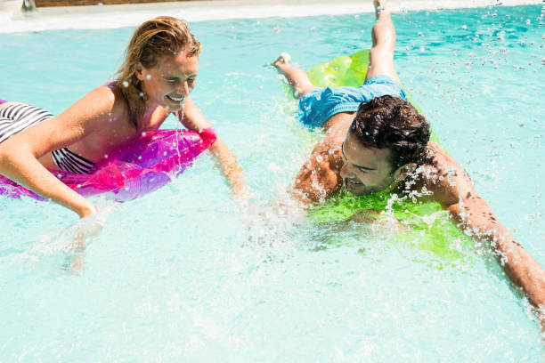 istock Happy couple on lilos splashing 843878110