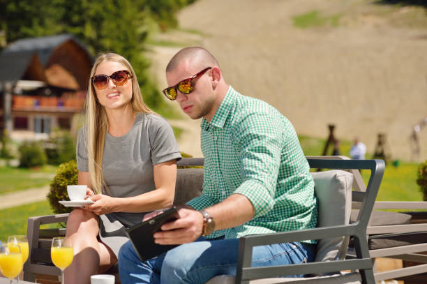 Young couple drinking coffee in their garden on a beautiful summer day