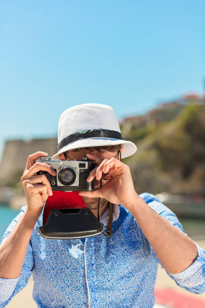 istock Hipster man photographer taking photo with retro camera 843885182