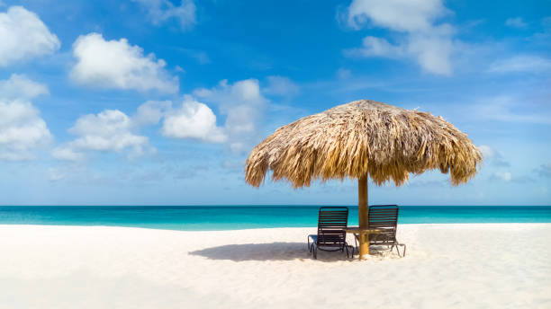 Straw umbrella on Eagle Beach, Aruba stock photo