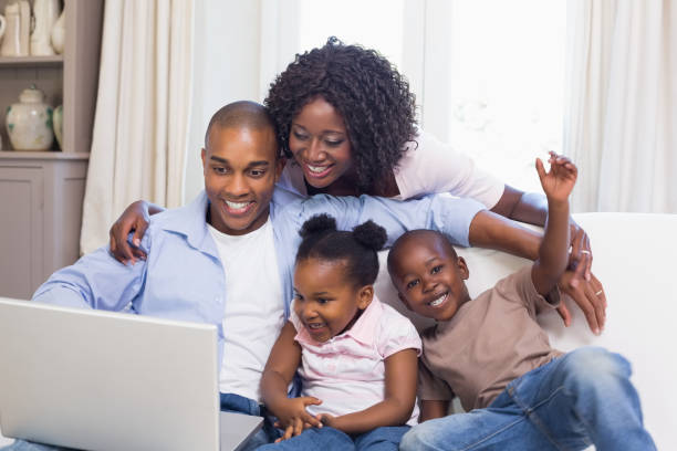 istock Happy family on the couch together using laptop 843888360