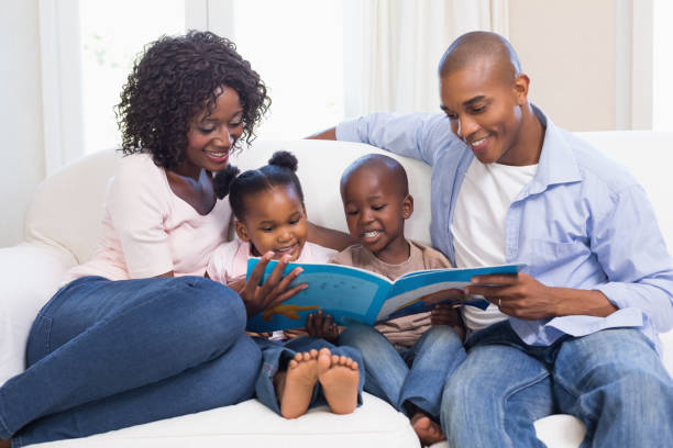 istock Happy family on the couch reading storybook 843888632