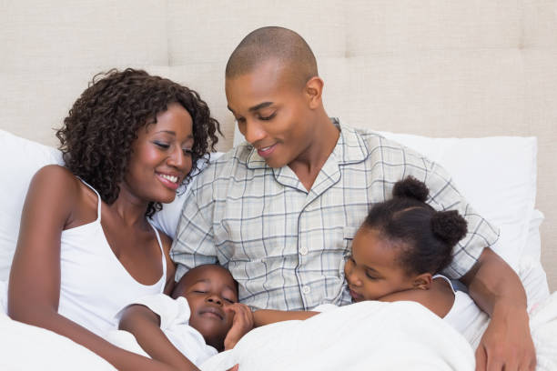 istock Happy family cuddling in bed together 843888998