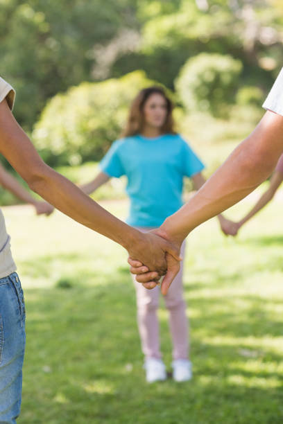 istock Group of friends holding hands in park 843892402