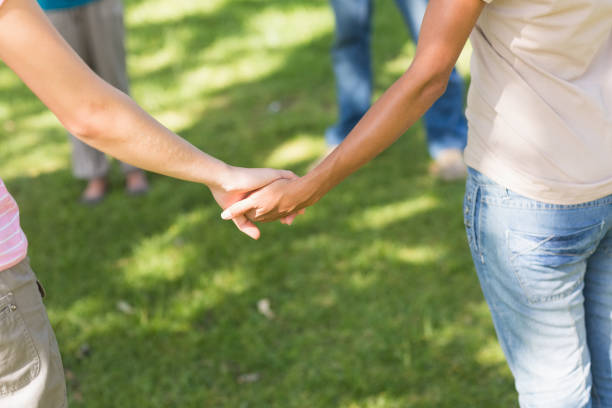 istock Group of friends holding hands in park 843892452