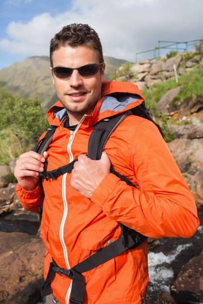 istock Man wearing rain jacket and sunglasses smiling at camera 843892934