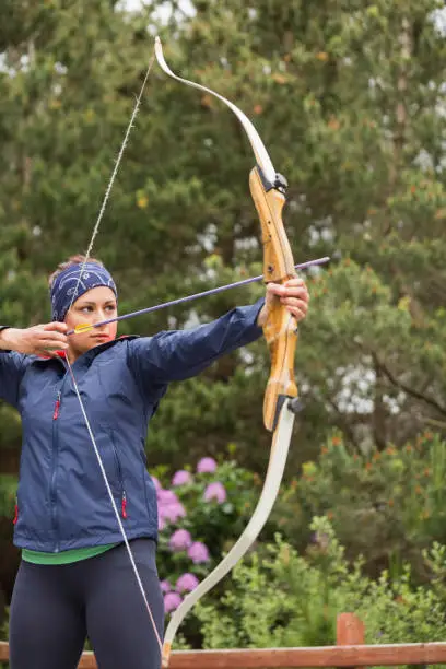 Photo of Focused brunette practicing archery