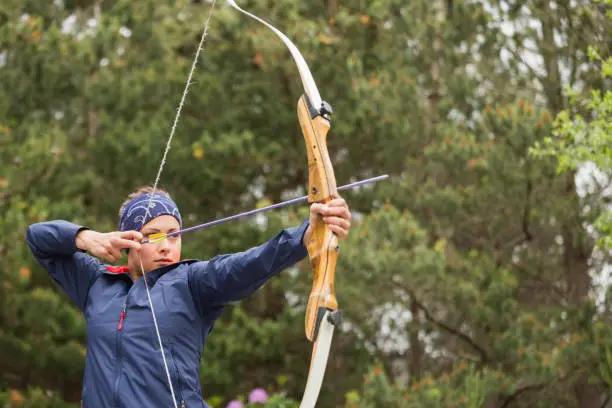 Photo of Concentrating brunette practicing archery