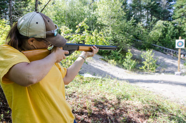 istock Woman aiming at target with rifle during outdoors summer day vacations 843899200