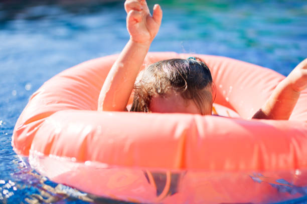 istock happy girl in swimming pool 843902272
