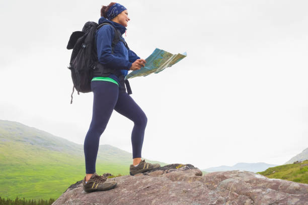 istock Woman standing on a rock holding map 843906818
