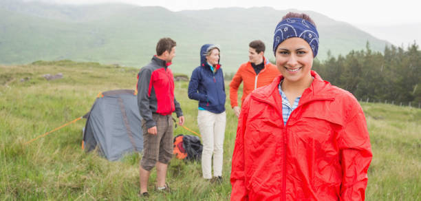istock Brunette smiling at camera with friends behind her on camping trip 843909260