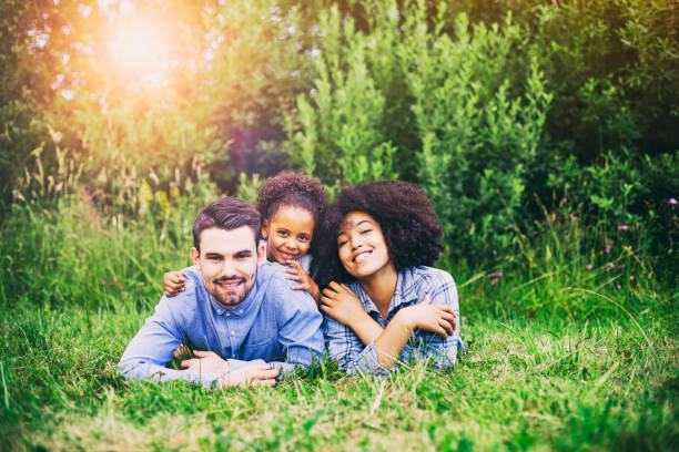 istock Happy family lying down on grass in park. 843909516