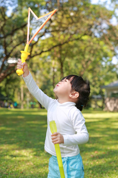istock Cute little girl playing bubble in the park. 843916610