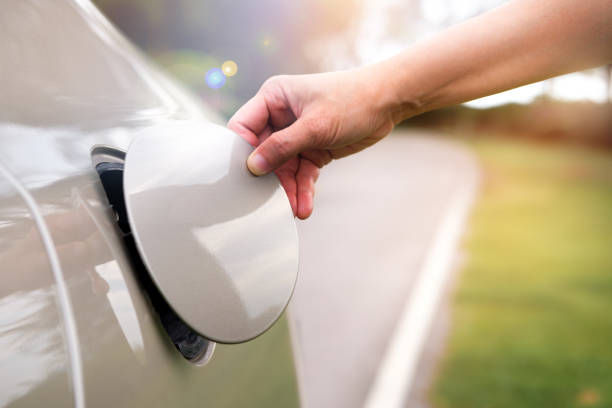 Hand open the car's oil cap to refuel.