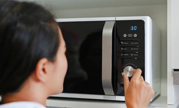 istock Woman using microwave oven at home. 843920804