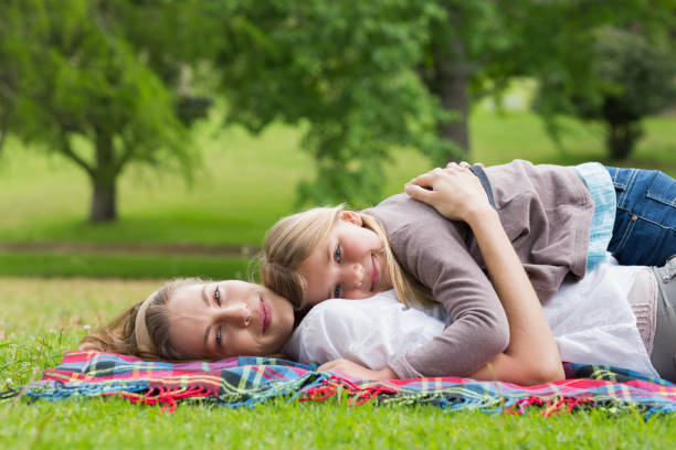 istock Relaxed mother and daughter lying at park 843921618