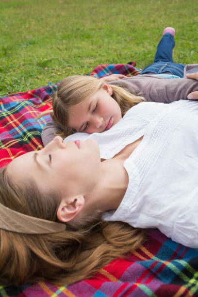 istock Relaxed mother and daughter lying at park 843921662