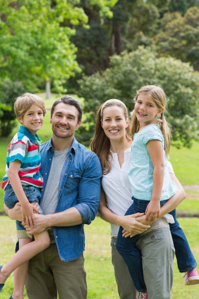 istock Happy parents carrying kids at park 843921954