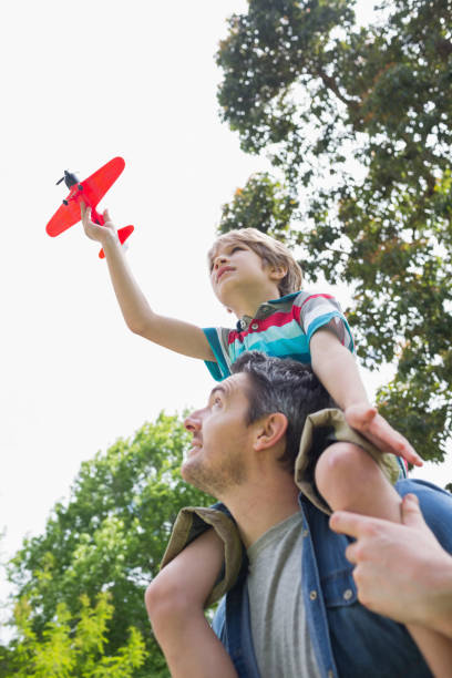istock Boy with toy aeroplane sitting on fathers shoulders 843923062