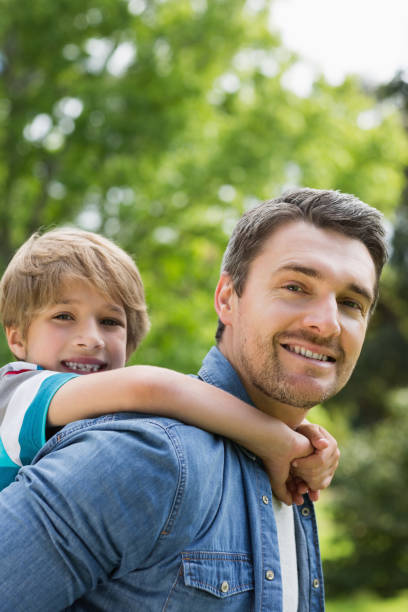 istock Portrait of a father carrying young boy on back 843924166