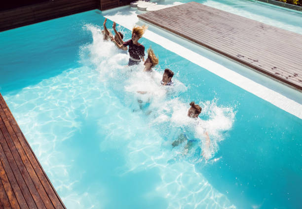 istock Happy friends jumping in the pool 843924490