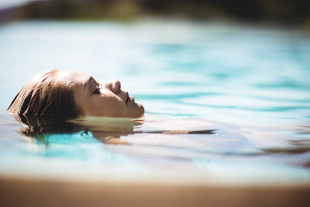 istock Peaceful blonde floating in the pool 843925224