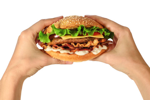 Hands holding a hamburger with lettuce, cheese and bacon on white background. Fast food.
