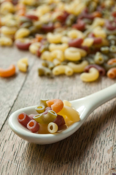 istock colorful pasta on a spoon on wooden background 843941516