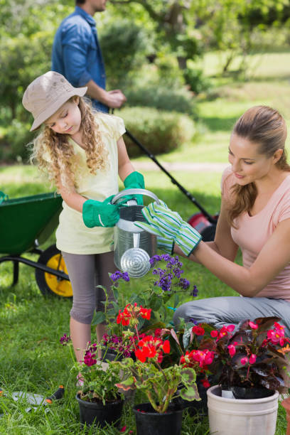istock Mother with daughter watering plants 843941706