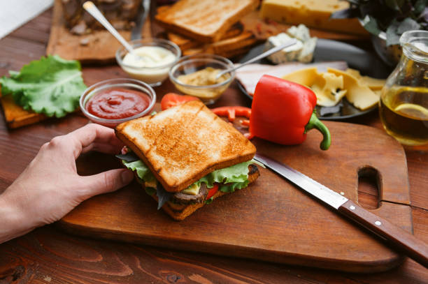 istock the hostess prepares a sandwich on a wooden table for guests 843950026