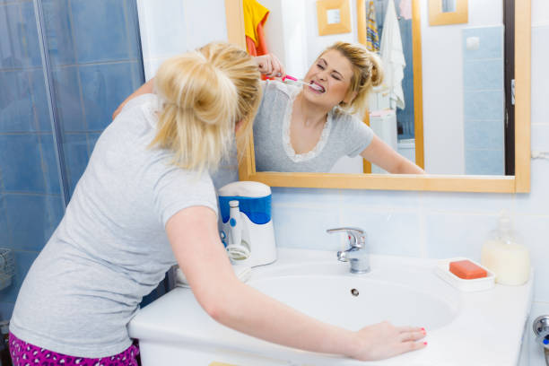 istock Woman brushing cleaning teeth in bathroom 843969926