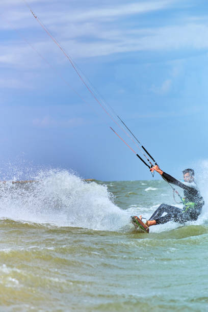 istock Man riding a kite surfing on the waves in the summer. 843972824