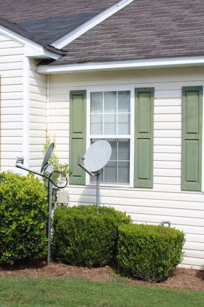 istock White and green house front with two satellite dishes in the front yard between the shrubs 843973034