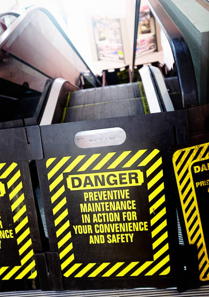 At the bottom of an escalator, a sign says Danger and warns of maintenance preventing use.